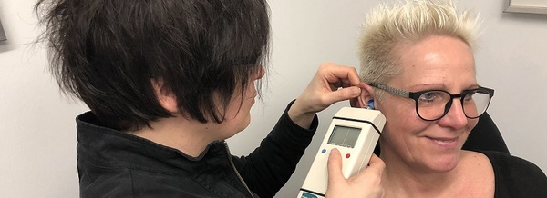 Hörtest beim Akustiker: Frau bekommt mit modernem Gerät ihr Gehör professionell gemessen.